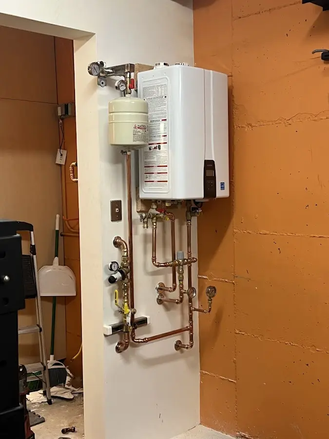Plumbing technician inspecting water heater connections in Northern Cambria